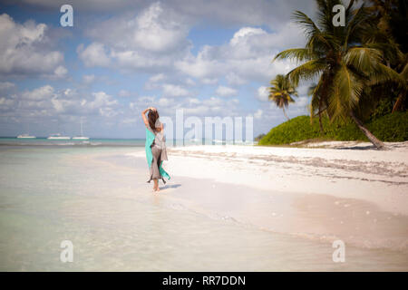 Frau geht an einem tropischen Strand Stockfoto