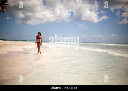 Frau geht an einem tropischen Strand Stockfoto