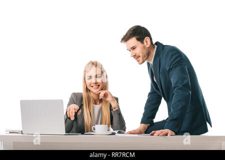 Blond Geschäftsfrau etwas auf Laptop mit Kollegen am Arbeitsplatz mit Tasse Kaffee Stockfoto