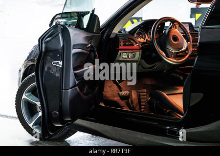 Dunkle Luxus auto Innenraum. Lenkrad, Schalthebel und Armaturentafel. Innenraum Luxus. Clima te Steuerung, Tacho, Display, Black Panels. Anzeigen Stockfoto