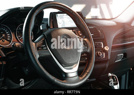 Dunkle Luxury Car Interior-Lenkrad, Schalthebel und Armaturentafel. Innenraum Luxus. Klimaanlage, Tacho, Display, Black Panels. Stockfoto
