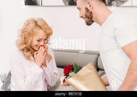 7/8-Ansicht der Mann mit Bart blumen Präsentation vor Staunen Freundin Stockfoto