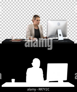 Auf Alpha-Matt. Schöne blonde Frau, Arbeiten am Computer, Alphakanal professionelle Aufnahme in 4K-Auflösung. 007. Sie können es z. B. in Ihrem commerc Stockfoto