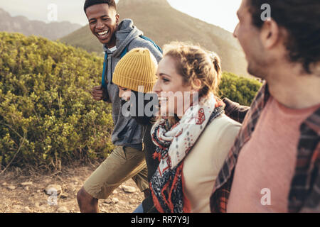 Fröhlicher junger Mann Lachen beim Wandern mit Freunden. Freunde Spaß haben auf ihrer Wanderung. Stockfoto