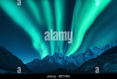 Aurora borealis über Snow Mountain Range in Europa abgedeckt. Nordlichter im Winter. Nacht Landschaft mit grünen Polarlichter und schneebedeckten Berge. S Stockfoto