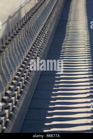 In der Nähe von städtischen Abstract der polierten Granit Balustrade und Schatten auf dem Gehsteig der King George V-Brücke. Glasgow, Schottland, Großbritannien. Stockfoto