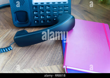 Büro Telefon auf Holz Tisch Konsole mit Notebooks Stockfoto