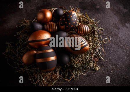 Ostern goldenen und schwarzen Eier mit geometrischen Muster auf dunklem Hintergrund Stockfoto