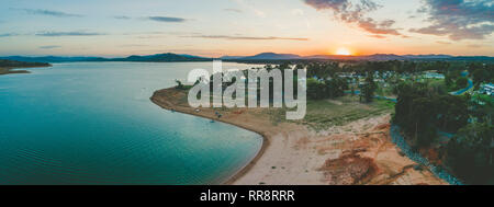 Sonne hinter den Bergen in der Nähe von Lake Hume Dorf - Luftbild panorama Verschwinden Stockfoto