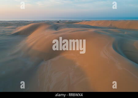 Unberührte Sanddünen in Orange sunrise Licht leuchten. Anna Bay, New South Wales, Australien Stockfoto