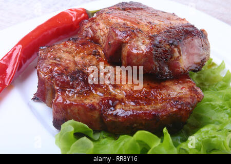 Rindfleisch Steak auf dem Grill und Chili mit Tomaten, Salatblätter auf weiße Platte Stockfoto