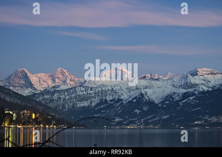 Berühmte Bergkette Eiger, Mönch und Jungfrau mit Schnee am Gipfel bei Sonnenuntergang in den Thunersee widerspiegelt.. Stockfoto