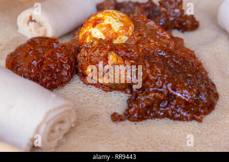 Afrikanische Speisen. Huhn und Ei Doro Wat mit Injera - ein sauerteig Fladenbrot aus teff Mehl gemacht. Es ist die National Food von Äthiopien, Eritrea, Somalia Stockfoto