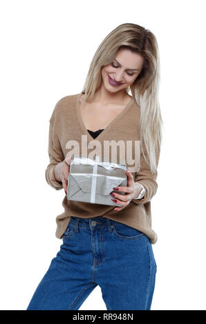 Vorderansicht einer Frau mit einer Geschenkbox. Vorderansicht Leute Sammlung. Auf weissem Hintergrund. Porträt einer stilvolle Blondine, lächelt looki Stockfoto