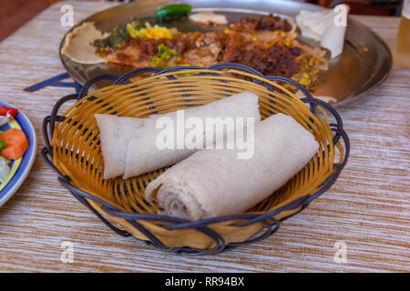 Afrikanische Speisen. Walzen der Injera - ein sauerteig Fladenbrot aus teff Mehl gemacht. Es ist dem nationalen Gericht aus Äthiopien, Eritrea, Somalia und Dschibuti Stockfoto