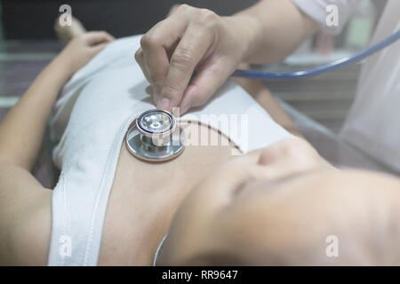 Der Arzt prüft asiatischen Mädchen und Heartbeat mit Stethoskop im Krankenhaus zu hören. Stockfoto