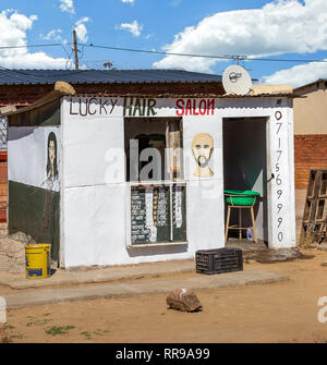 Johannesburg, Südafrika, 9. November - 2018: Lokale Friseur in einer ländlichen Gegend. Barbershop mit Schild mit verschiedenen Schnitten. Stockfoto