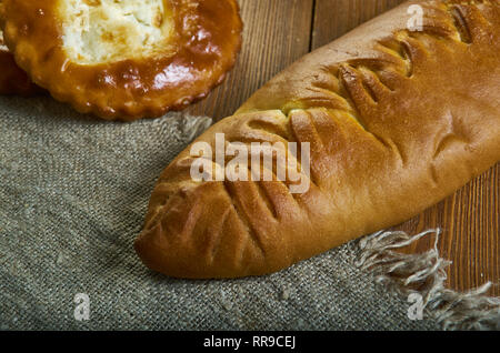 Coulibiac, Russische traditionelle Kuchen piroshki, verschiedene Backwaren: Geschirr, Ansicht von Oben. mit Lachs und Stör, Reis oder Buchweizen, hart gekochte Eier, mushroo Stockfoto