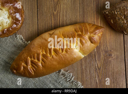 Coulibiac, Russische traditionelle Kuchen piroshki, verschiedene Backwaren: Geschirr, Ansicht von Oben. mit Lachs und Stör, Reis oder Buchweizen, hart gekochte Eier, mushroo Stockfoto