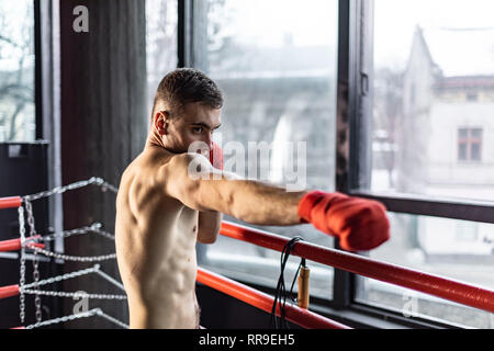 Punhing Mann mit roten Bandagen im Ring Stockfoto