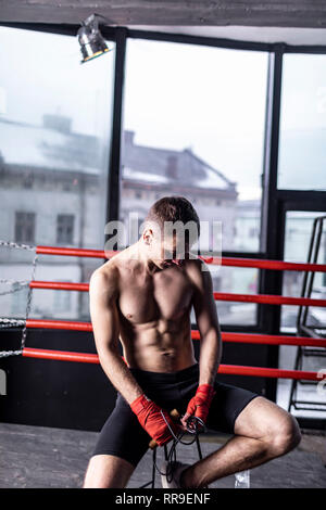 Muskulöse Athleten Mann mit Seil sitzen auf Stuhl in den Ring Stockfoto