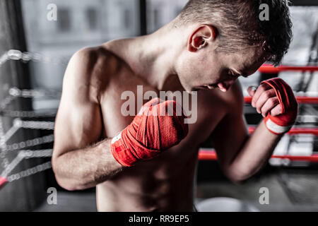 Nahaufnahme von Boxer Mann mit roten Bandagen im Ring Stockfoto