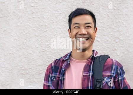 Asiatische Mann draußen stehen in der Stadt und lachte Stockfoto