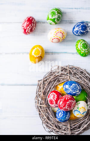 Close-up bunte Ostereier im Korb auf Holztisch. Stockfoto