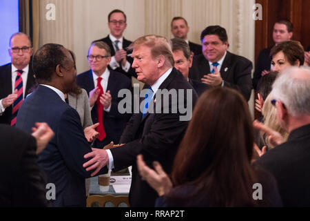 Präsidenten der Vereinigten Staaten Donald J. Trumpf schüttelt Hände mit US-Staatssekretär für Wohnungswesen und Stadtentwicklung (HUD) Ben Carson, als er eine Gruppe der Gouverneure während der 2019 White House Business Session im Weißen Haus in Washington, DC, die am 25. Februar 2019. Trump diskutiert die Gruppe auf die Infrastruktur, die Opioid Epidemie, Grenzsicherheit und China Handelspolitik. Credit: Kevin Dietsch/Pool über CNP | Verwendung weltweit Stockfoto