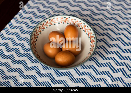 Schüssel Eier, 5 braune Eier in eine Schüssel geben. Stockfoto