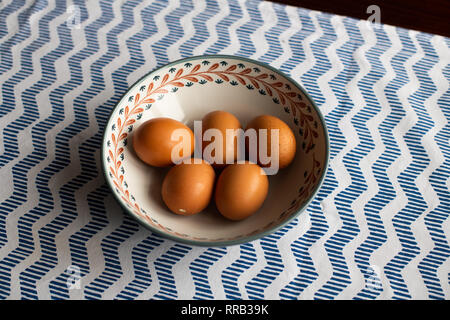 Schüssel Eier, 5 braune Eier in eine Schüssel geben. Stockfoto