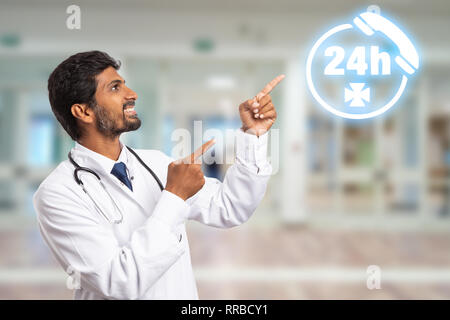Indische medic mit Zeigefinger für die Präsentation von Phone Symbol als All-tag Hilfe am Krankenhaus Konzept Stockfoto