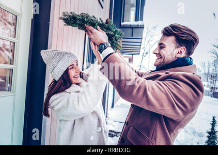 Der bärtige Mann, Weihnachten Kranz oh Kopf seiner Frau Stockfoto