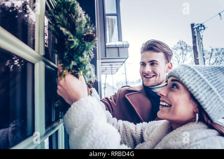 Glückliche Ehefrau Gefühl super Dekoration Haus mit Kranz Stockfoto