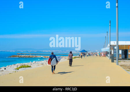 COSTA DA CAPARICA, Lissabon, Portugal - 17. SEPTEMBER 2018: die Menschen zu Fuß durch die Strandpromenade im sonnigen Sommertag. Costa da Caparica ist der berühmte Stockfoto