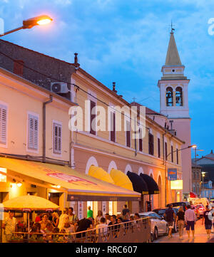 NOVIGRAD, KROATIEN - 20. AUGUST 2017: Leute an einem Street Restaurant bei Dämmerung in Novigrad. Novigrad ist Touristen beliebten Badeort in Croati Stockfoto