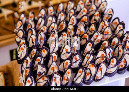 Rollen schwarz Pfannkuchen mit Käse, Lachs und roter Kaviar auf die weiße Platte, schöne Präsentation. Stockfoto