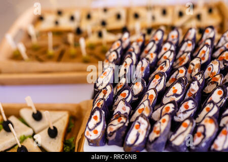 Rollen schwarz Pfannkuchen mit Käse, Lachs und roter Kaviar auf die weiße Platte, schöne Präsentation. Stockfoto
