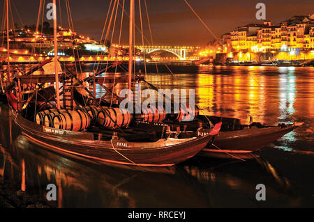 Historischer Hafen Wein Schiffe mit Weinfässern Verankerung auf dem Fluss Douro bei Nacht Stockfoto