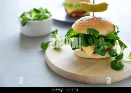 Leckere hausgemachte vegane Burger mit Gemüse und Grüns auf grau Holz- Hintergrund. Platz kopieren Stockfoto