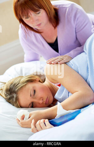 Junges Mädchen im Bett mit der Grippe festgelegt Stockfoto