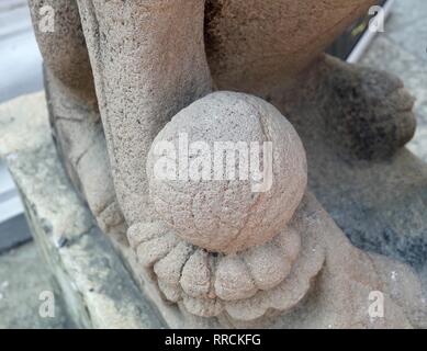 Alte chinesische Löwe Skulptur oder Erziehungsberechtigten Lion Holding eine Kugel im rechten Fuß am Eingang oder das innere Heiligtum, Symbol für Schutz und Leistung in Oder Stockfoto