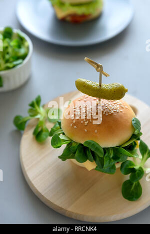 Leckere hausgemachte vegane Burger mit Gemüse und Grüns auf grau Holz- Hintergrund. Platz kopieren Stockfoto