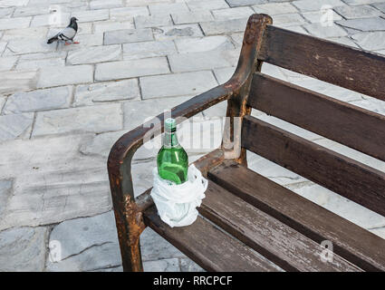 Leeres Glas Bier Flasche auf Parkbank Stockfoto