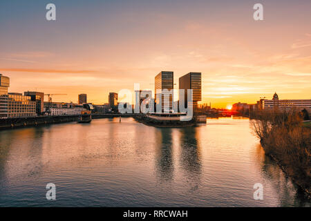 Düsseldorf, Deutschland - 25. Februar 2019: Die modernen Gebäude der Neuen Medien Hafen Trübsinn in der untergehenden Sonne Licht. Stockfoto