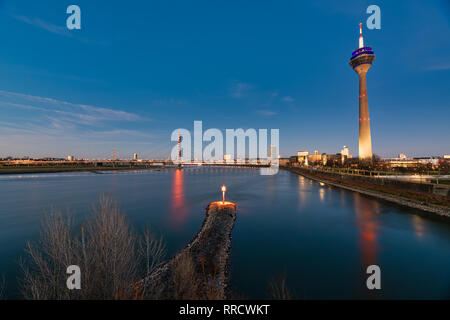 Düsseldorf, Deutschland - 25. Februar 2019: Die Lichter der Altstadt und der Fernsehturm Trübsinn während der blauen Stunde und einen lebendigen Kontrast schaffen. Stockfoto
