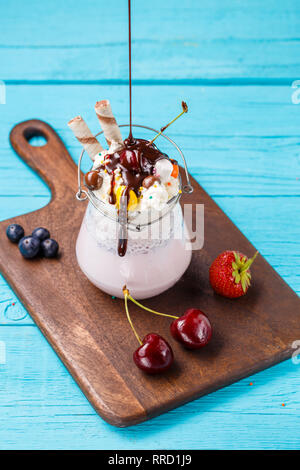 Frische kirsche Milchshake und Beeren besprüht Schokolade. Stockfoto