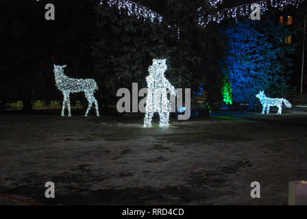 Bären, Hirsche und Fox von den Birnen. Weihnachtsschmuck auf der Straße in der Nacht. Stockfoto