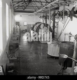 1950, historische, in einer Molkerei, eine Arbeiterin in einer großen butterfass, Irland. Stockfoto