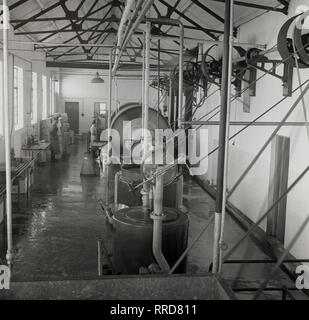 1950, historische, in einer Molkerei, eine Arbeiterin in einer großen butterfass, Irland. Stockfoto